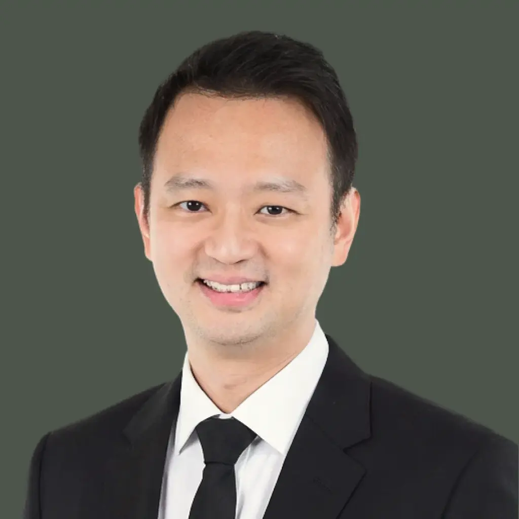 dr philemon huang with black suit against a green background
