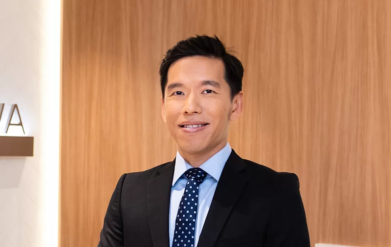 Dr Leslie Ang Pek Seng with black suit in an office